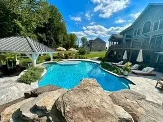 there is a large swimming pool in the backyard of a house