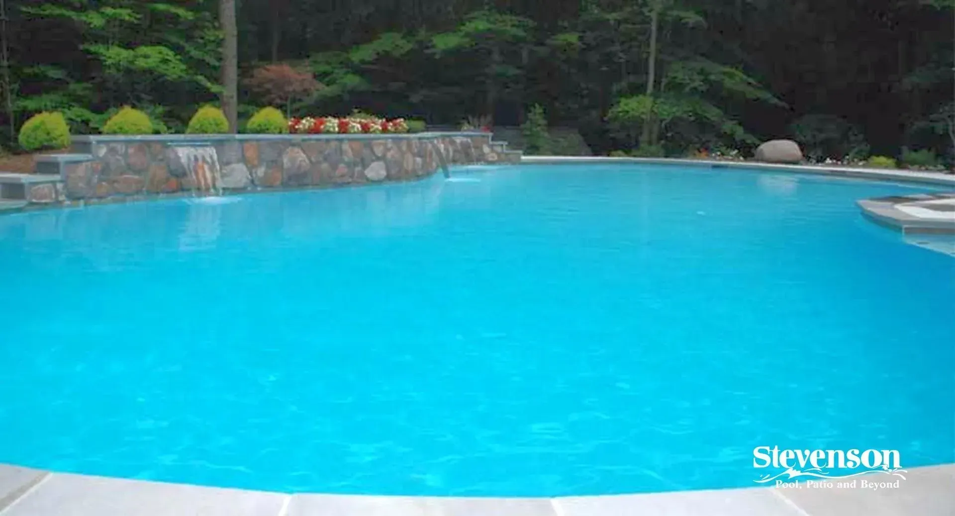 a large swimming pool filled with blue water in a backyard