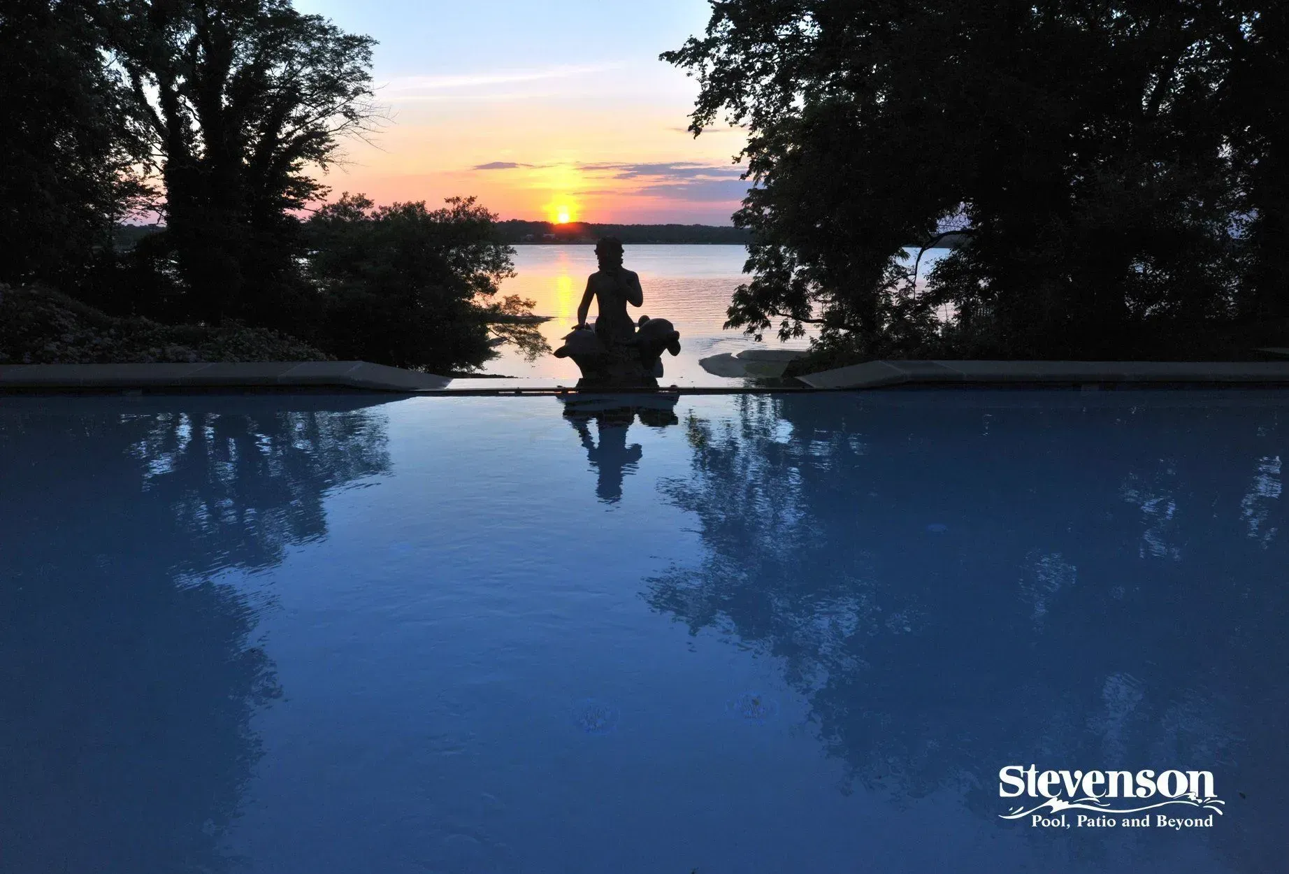 a statue of a woman riding a horse is reflected in a pool