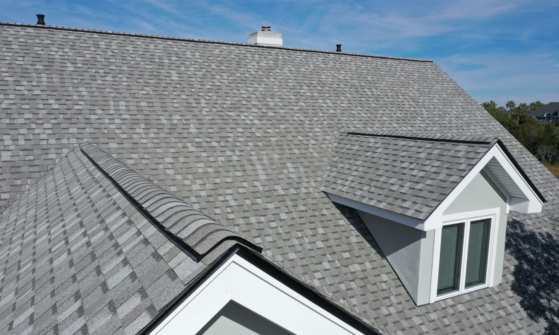 An aerial view of a house with a gray roof and a window.