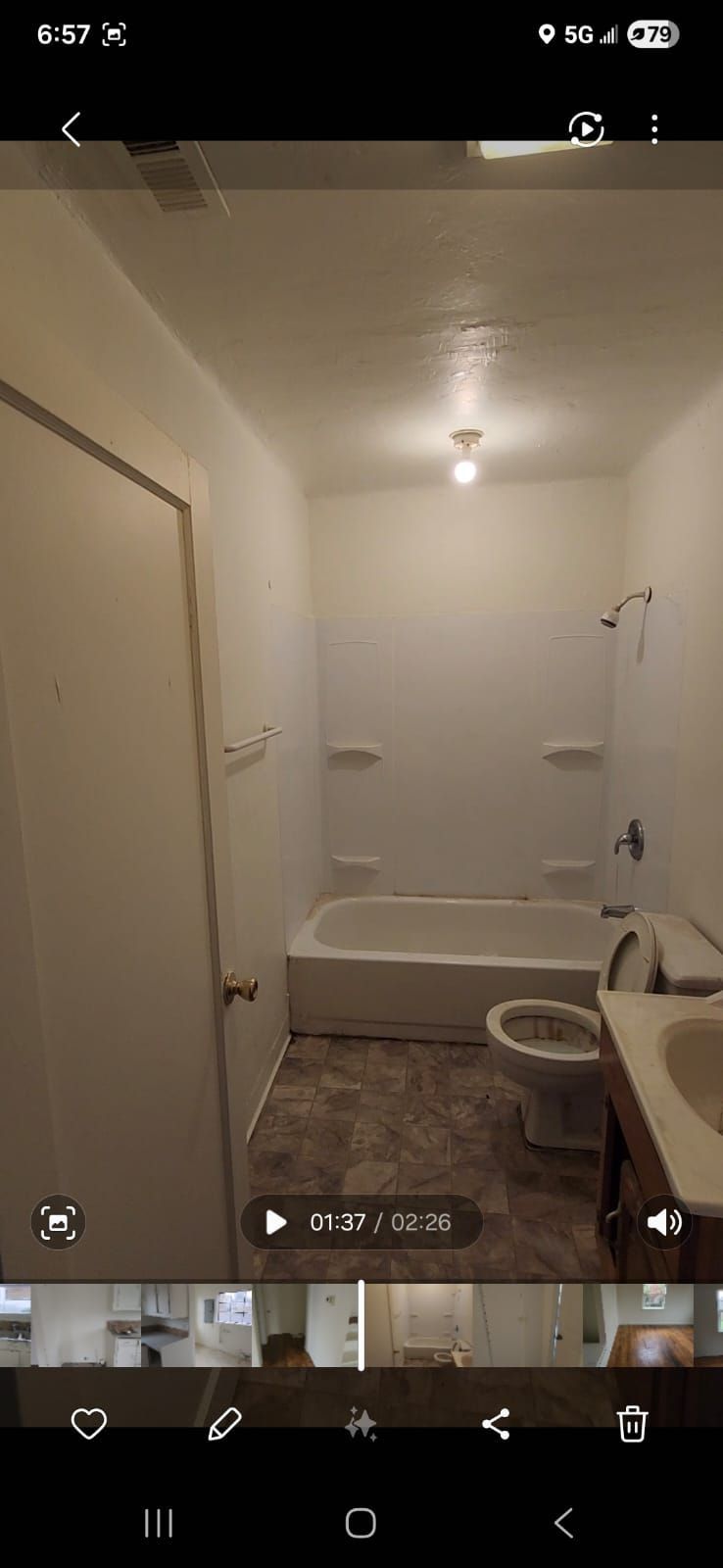 Small bathroom with a bathtub, toilet, sink, white walls, and a single ceiling light.