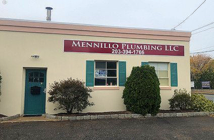 Mennillo Plumbing LLC storefront with maroon sign, cream exterior, teal door, and green shutters