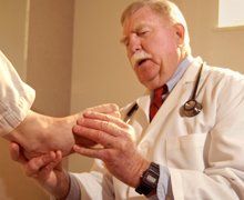 old doctor checking a foot