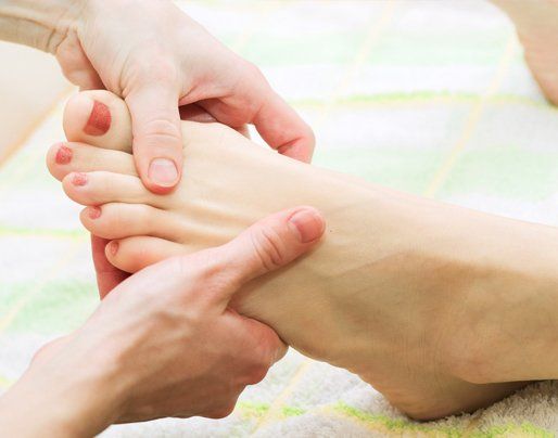 pair of hands massaging a foot