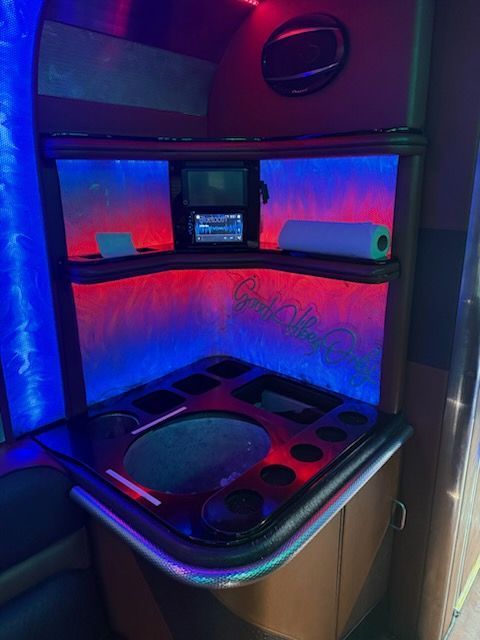 Built-in corner cabinet with blue/red LED lighting. Includes a sink, shelves, and a paper towel roll.