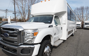 White shuttle bus parked outside on a sunny day.