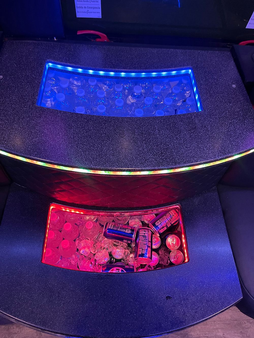 Glowing tabletop with red and blue lights illuminating coin-filled sections.