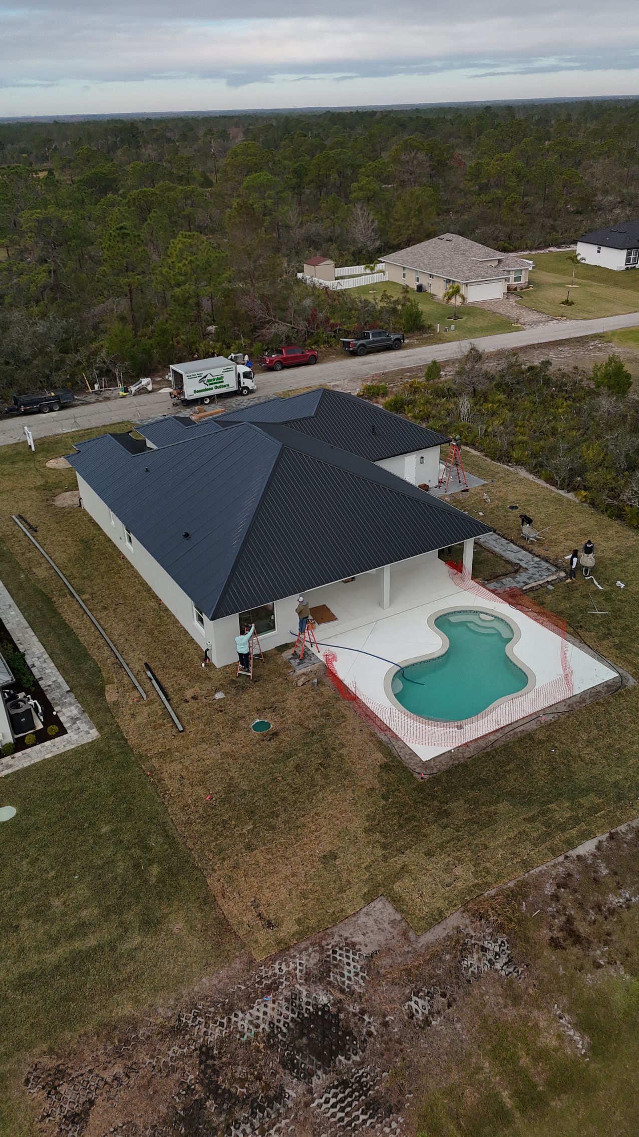 An aerial view of a house with a pool in the backyard.