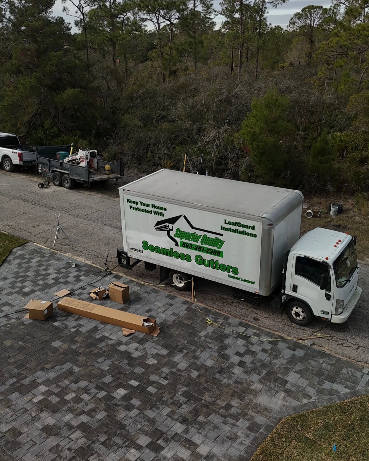 An aerial view of a moving truck parked on the side of a road.