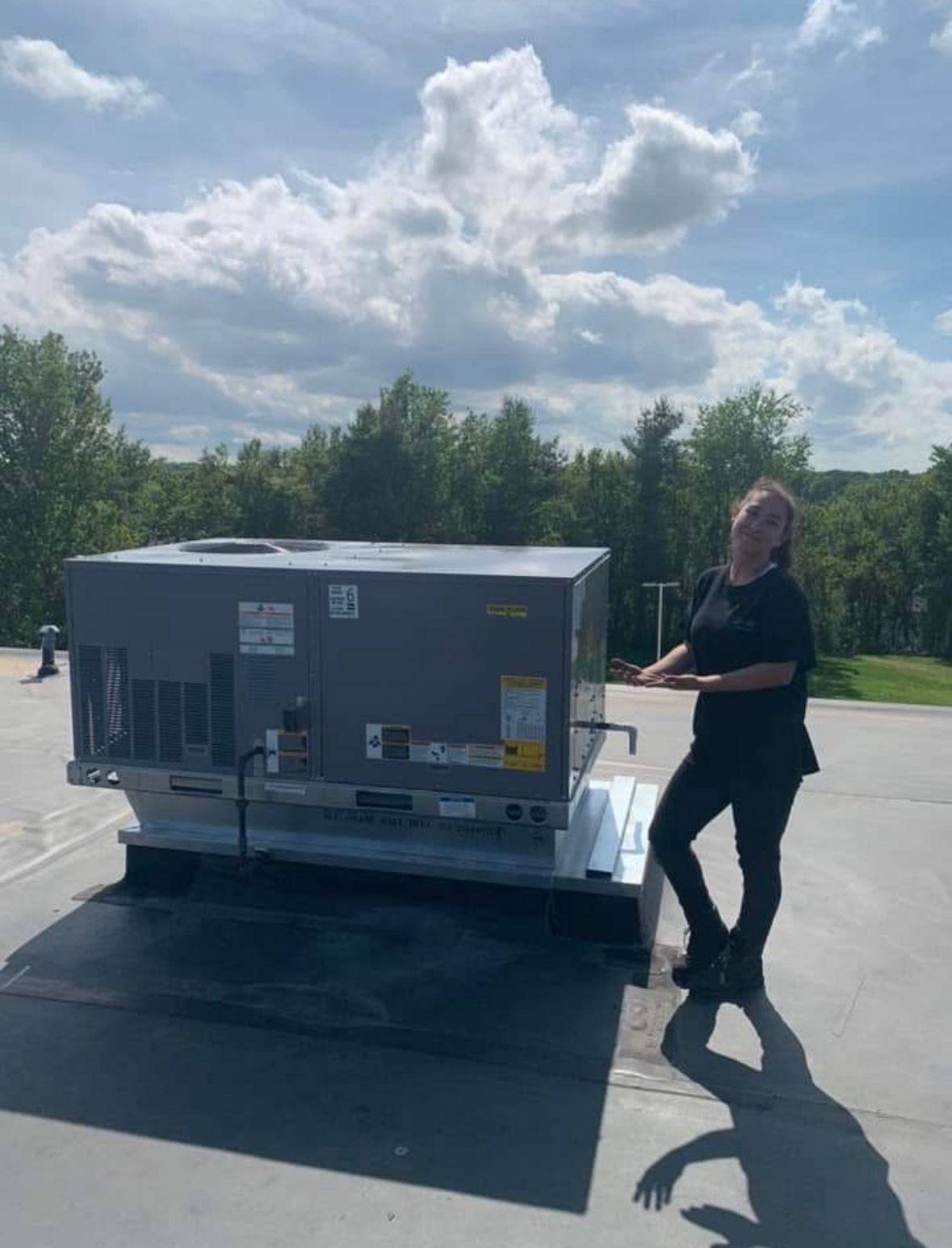 A woman is standing in front of a large gray box.