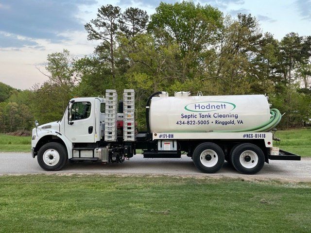 White Hodnett Septic Tank Cleaning truck on a road.