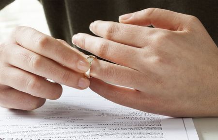 A woman is removing a wedding ring