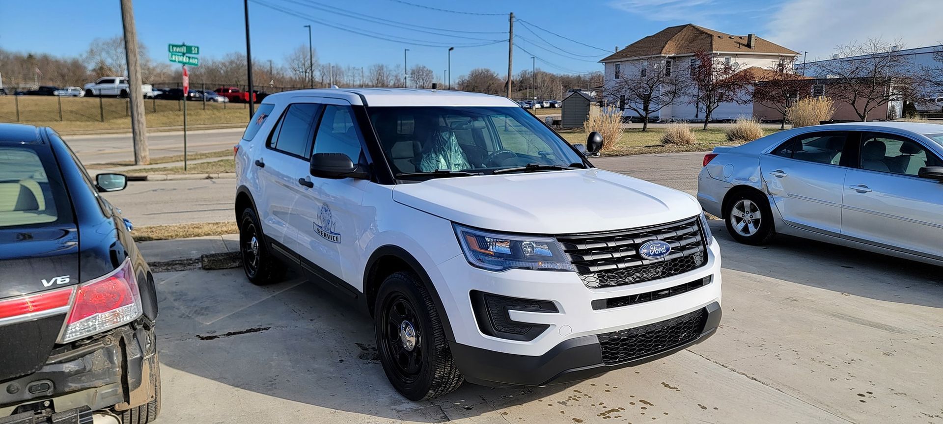 A white ford explorer is parked in a parking lot next to a silver car