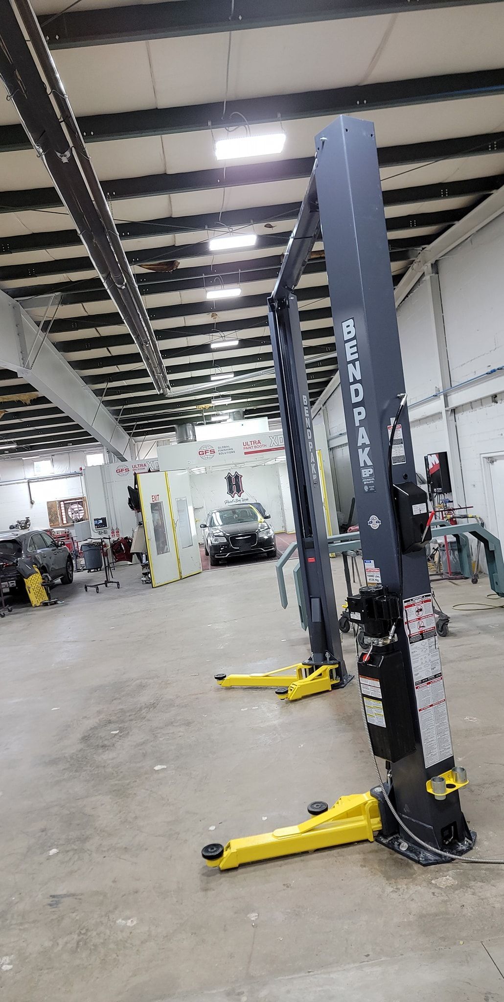 A car lift is sitting in the middle of a garage