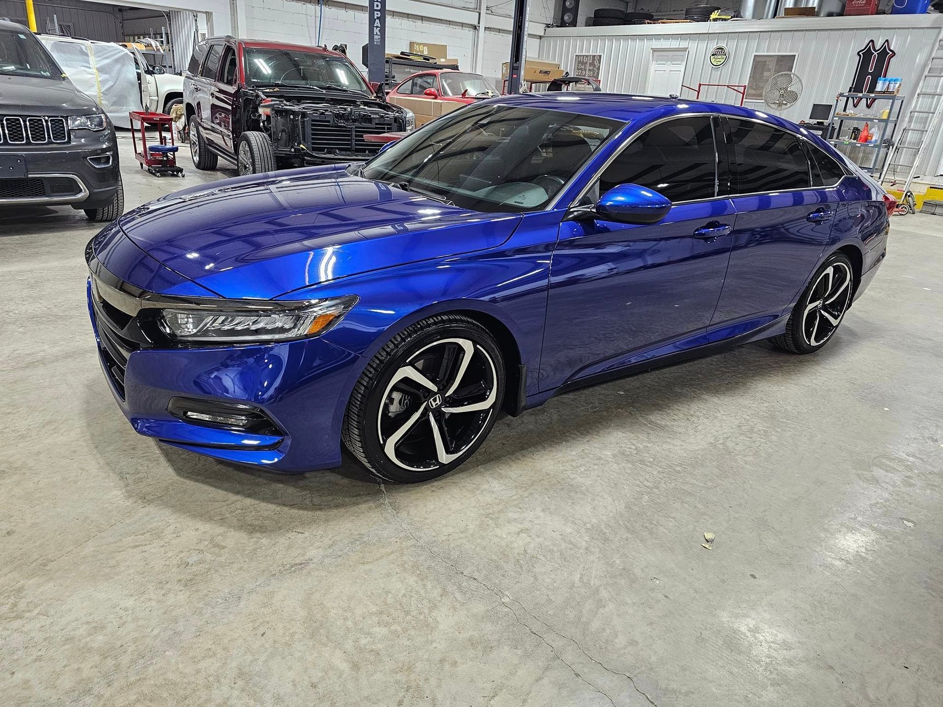 A blue Honda Accord is parked in a garage