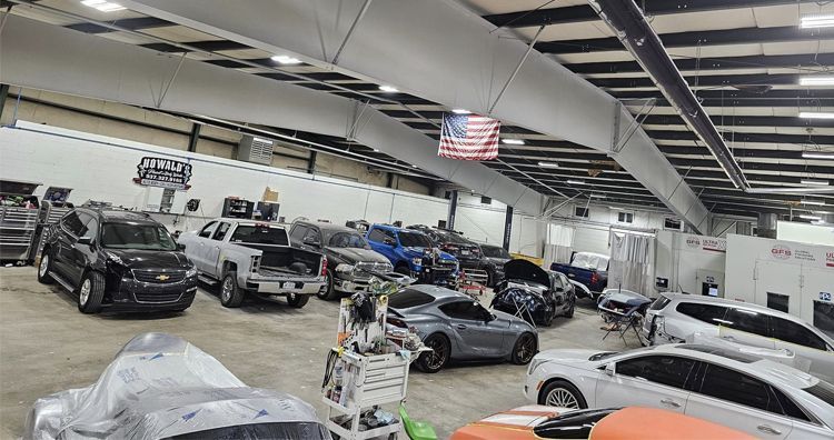 A large warehouse filled with lots of cars and trucks