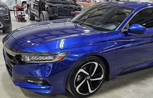 A blue Honda Accord is parked in a garage