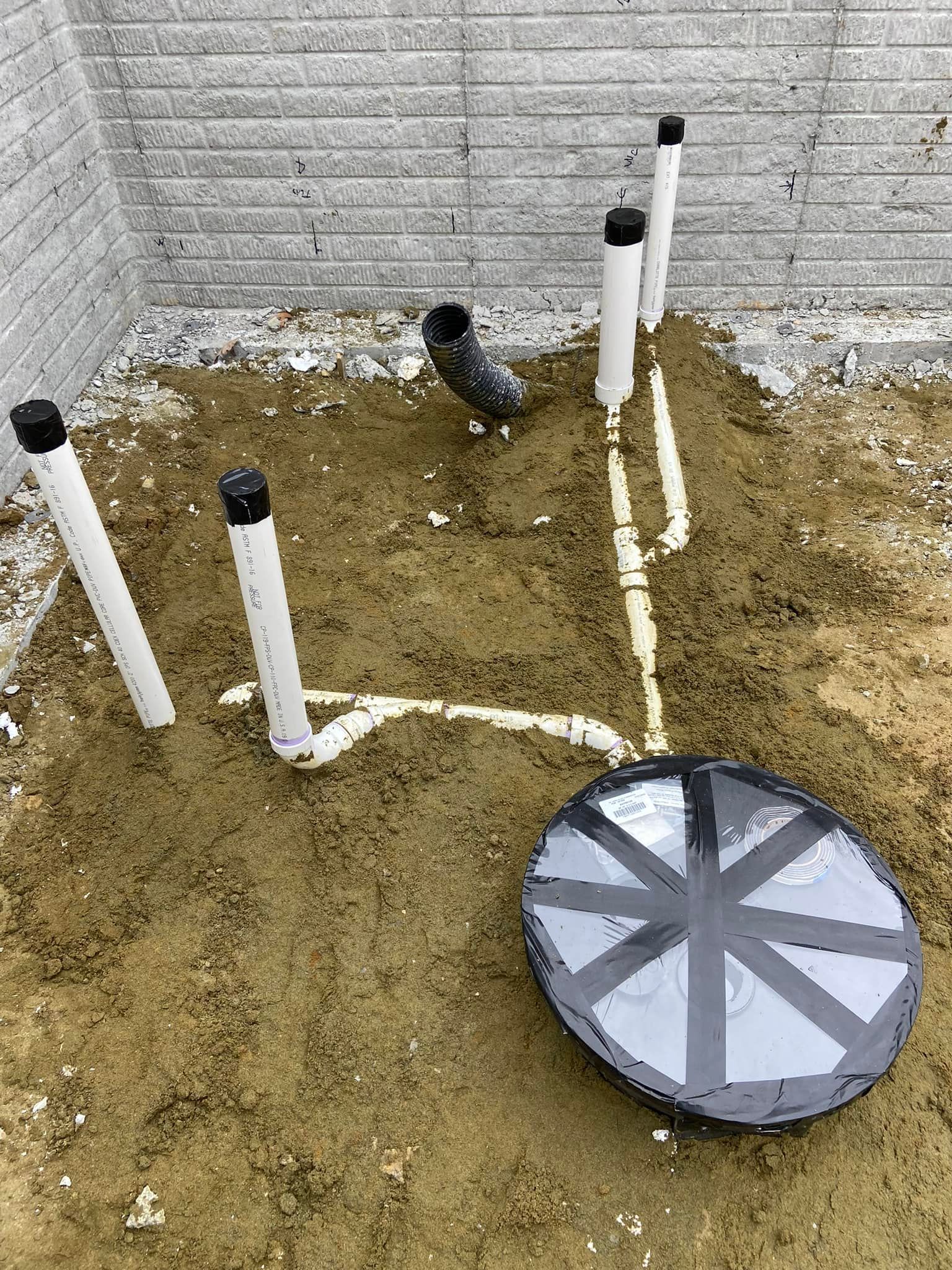 A circular object is sitting in the middle of a pile of dirt.