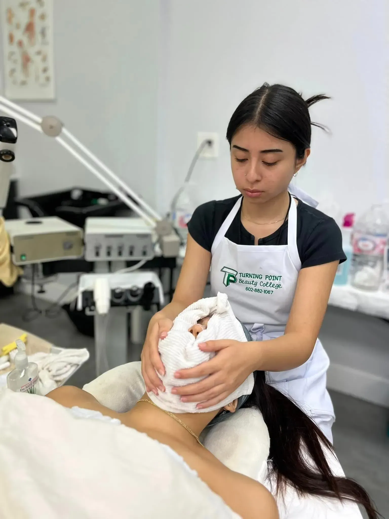Person in apron giving facial to client in a spa setting.