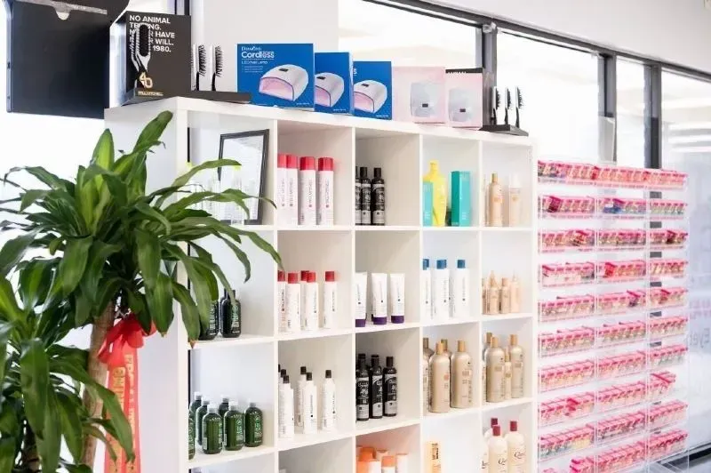 Shelves displaying beauty products, a plant, and nail polish samples.