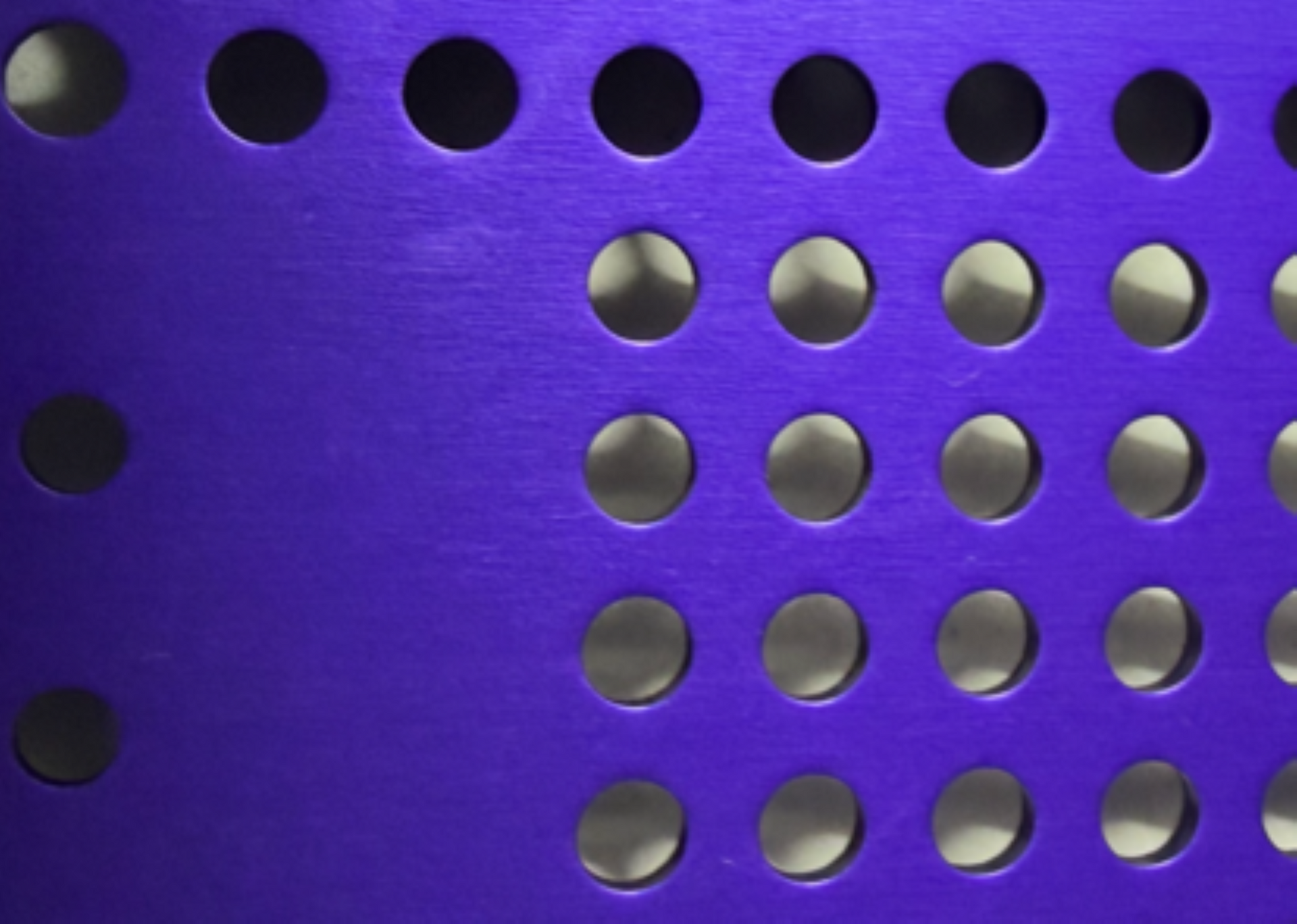 Purple perforated metal panel with round holes.
