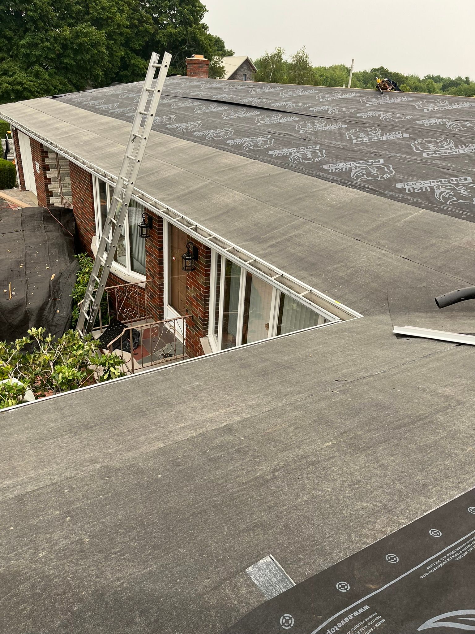 Flat roof on a brick building with vents and trees in the background