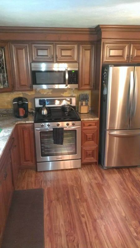 Modern kitchen with dark wood cabinets, stainless steel appliances, and hardwood flooring