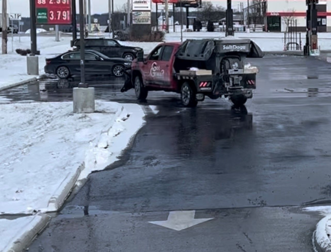 a red truck is parked in a snowy parking lot