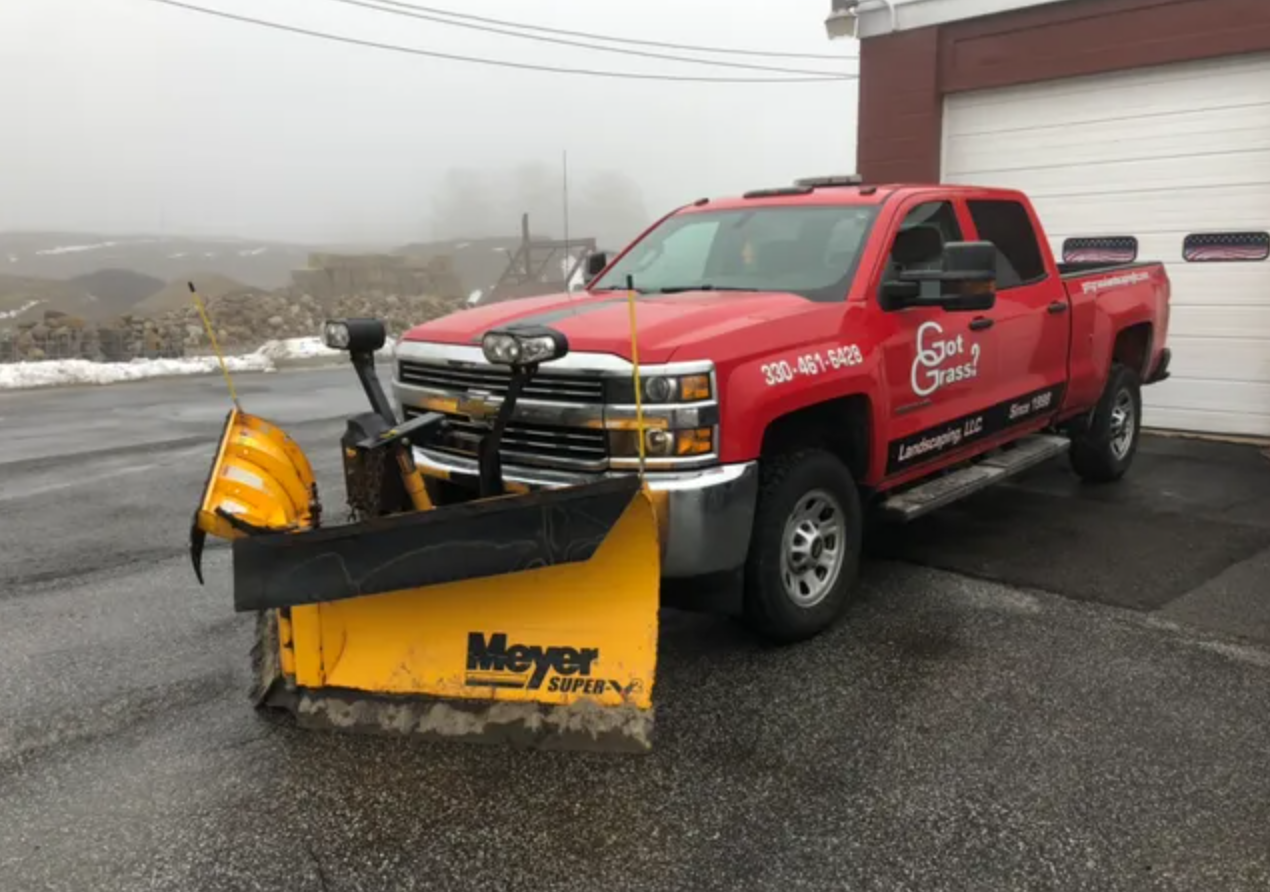a red truck with a snow plow attached to it