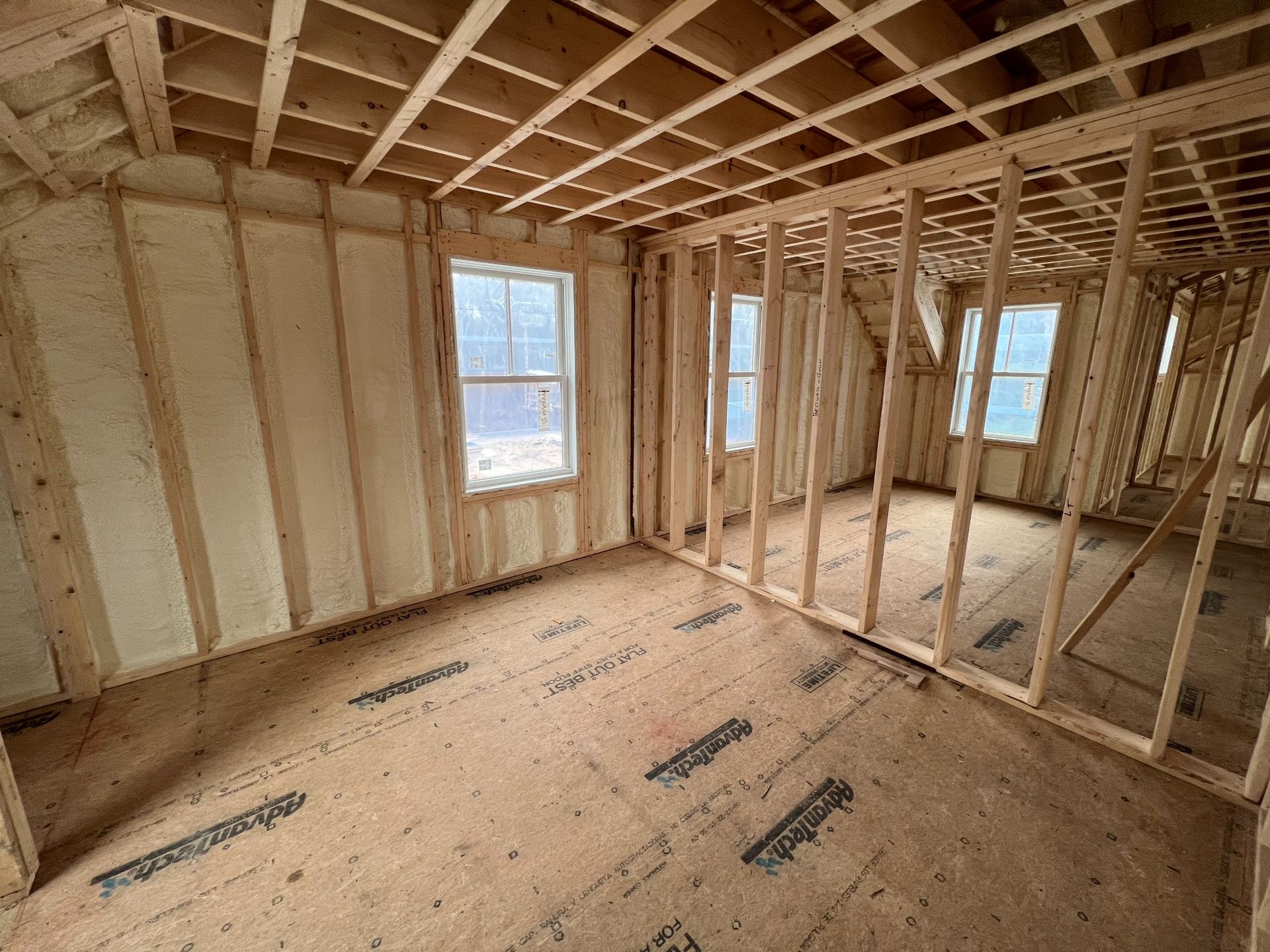 A room in a house under construction with wooden walls and a wooden floor.