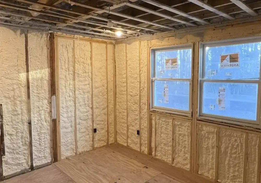 A room with foam insulation on the walls and windows.