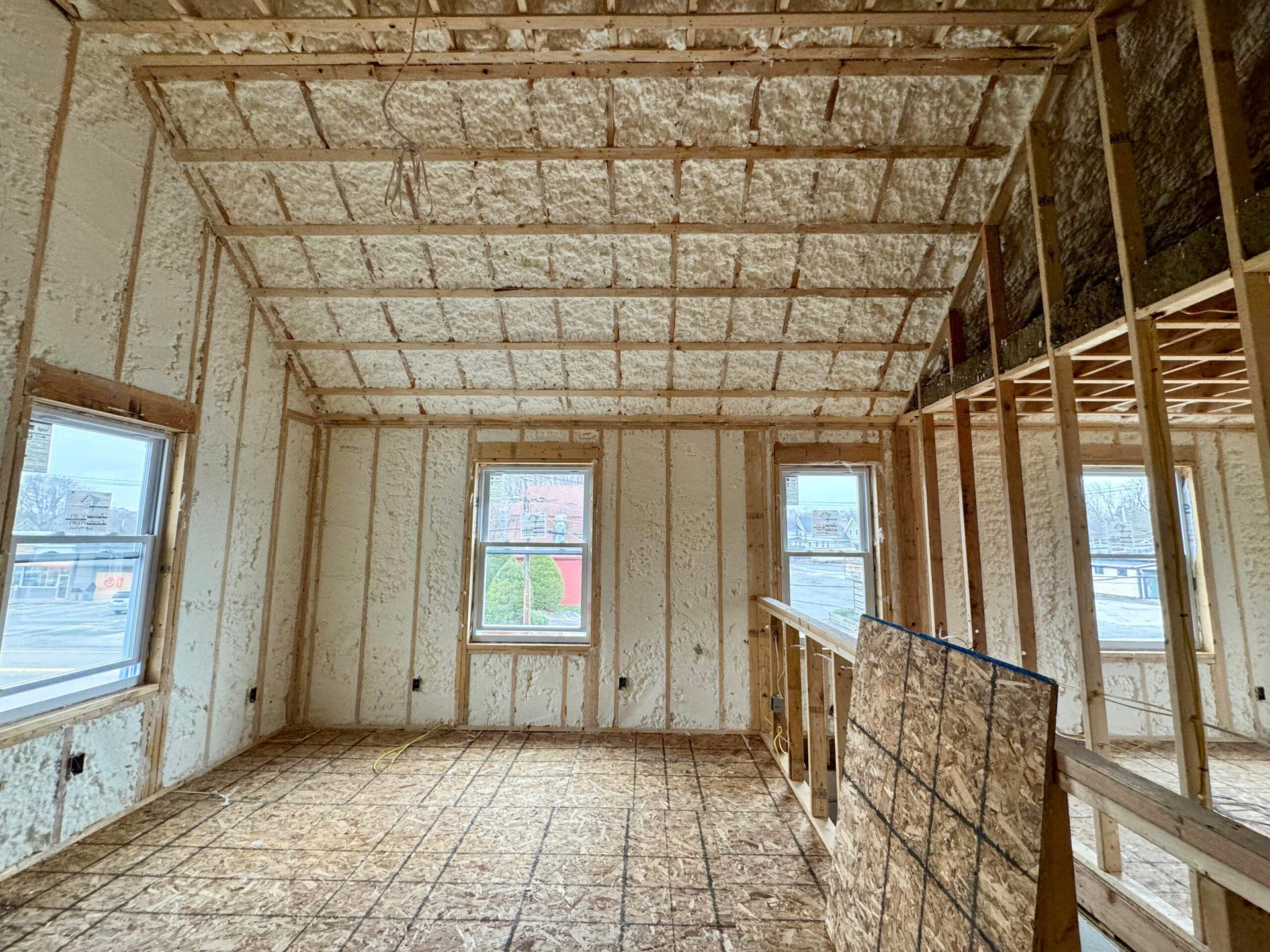 A room in a house under construction with a lot of insulation on the walls and ceiling.