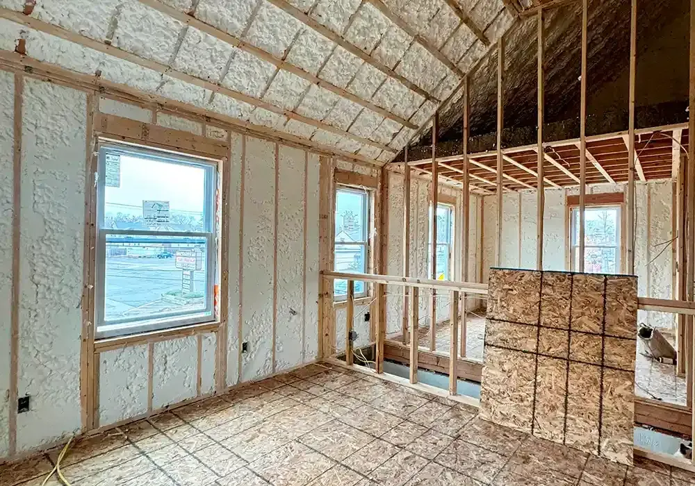 A room in a house under construction with insulation on the walls and ceiling.