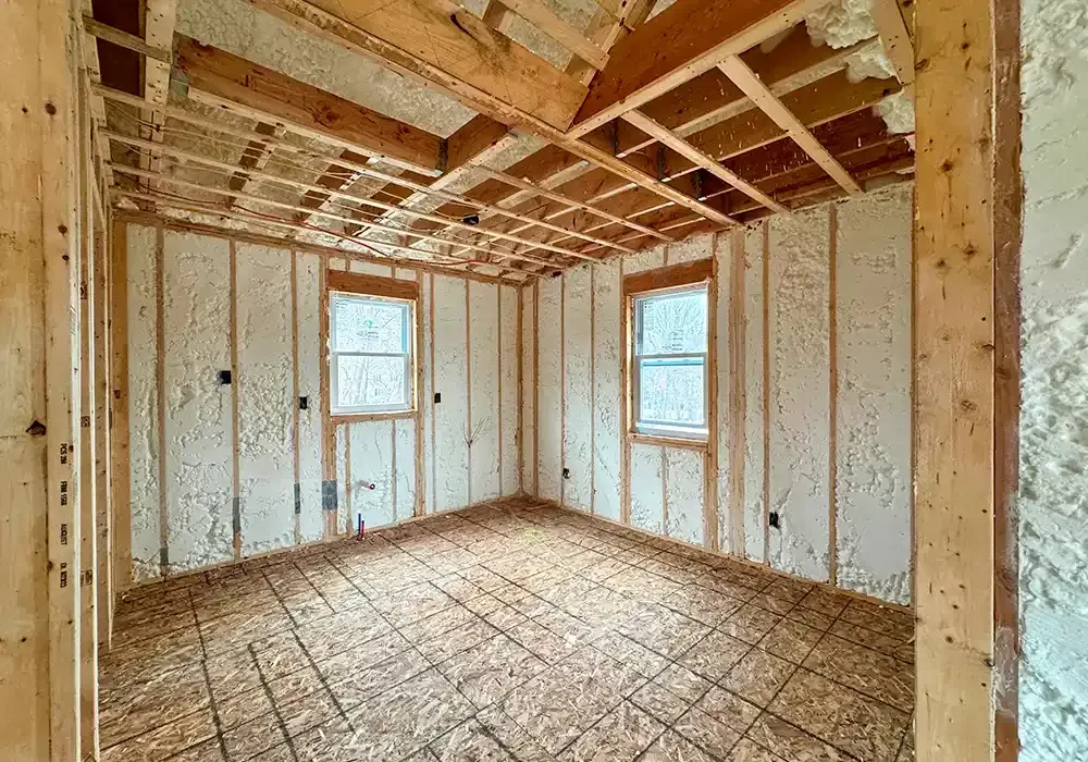 A room in a house under construction with insulation on the walls and ceiling.