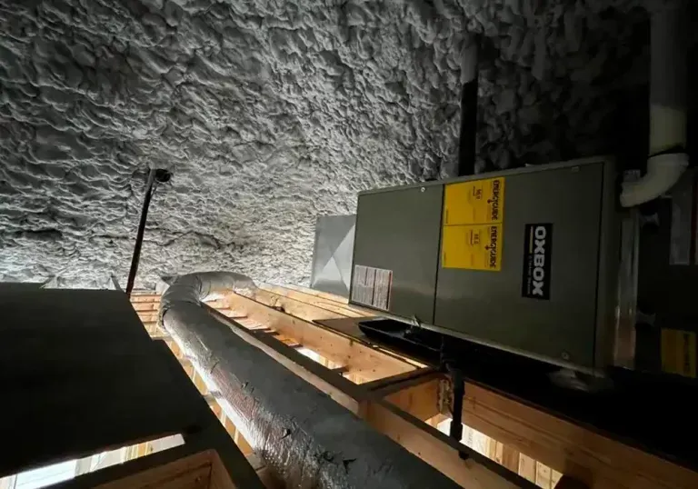 A ceiling with a box and pipes hanging from it.