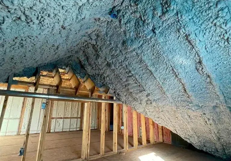 A room with a lot of blue spray foam on the ceiling.