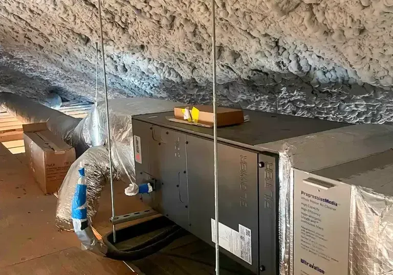 An air conditioner is sitting in the attic of a house.