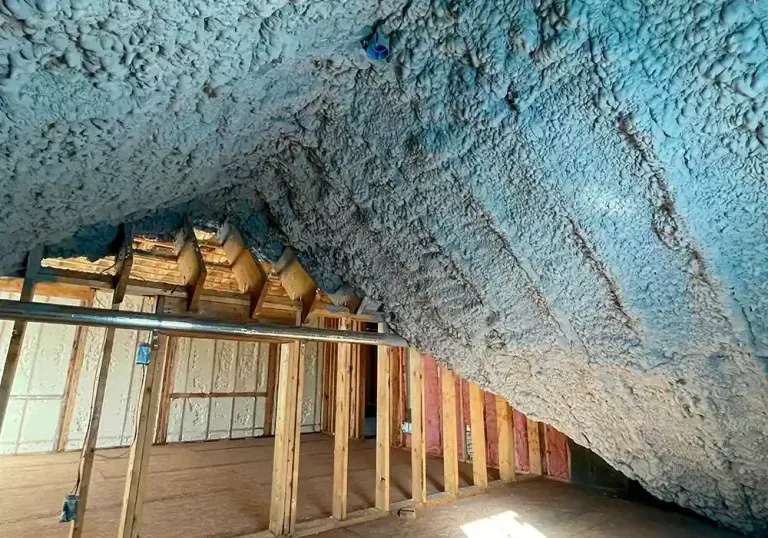 A room with a lot of blue spray foam on the ceiling.