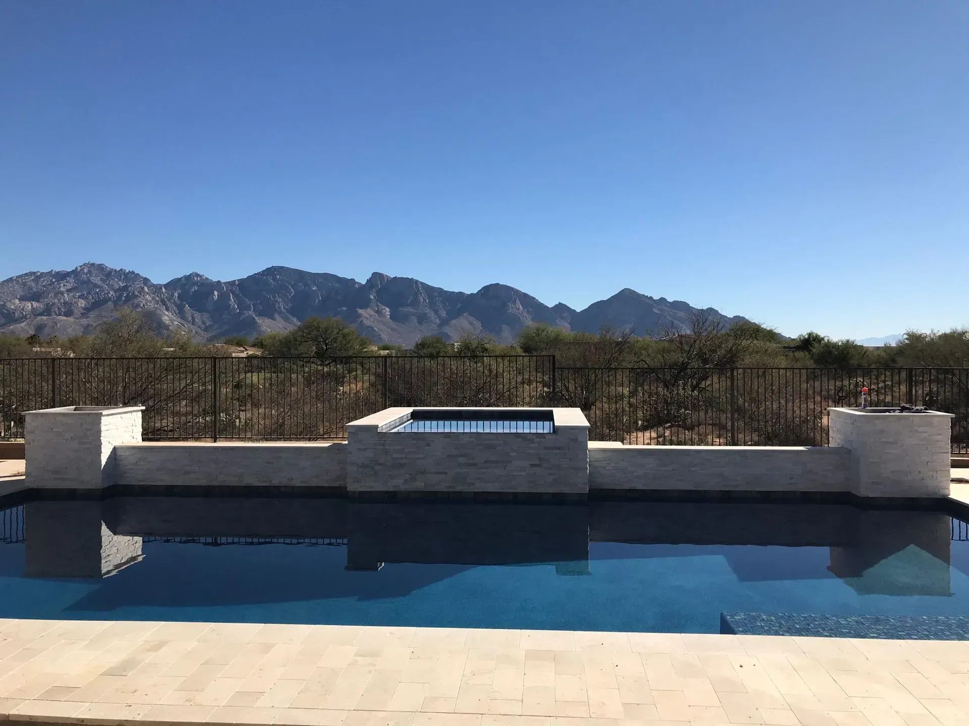 Swimming pool with a view of mountains under a clear blue sky.