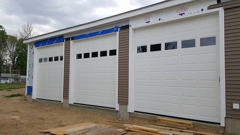 Three white garage doors on a building