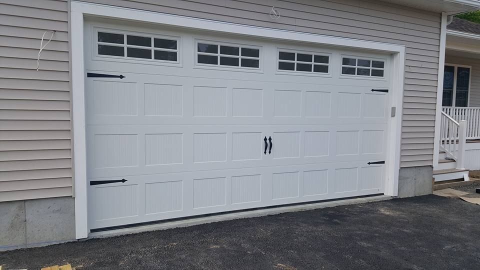White garage door with decorative black hardware and windows