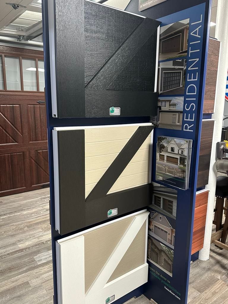 Display of residential garage door samples in black, tan, and white