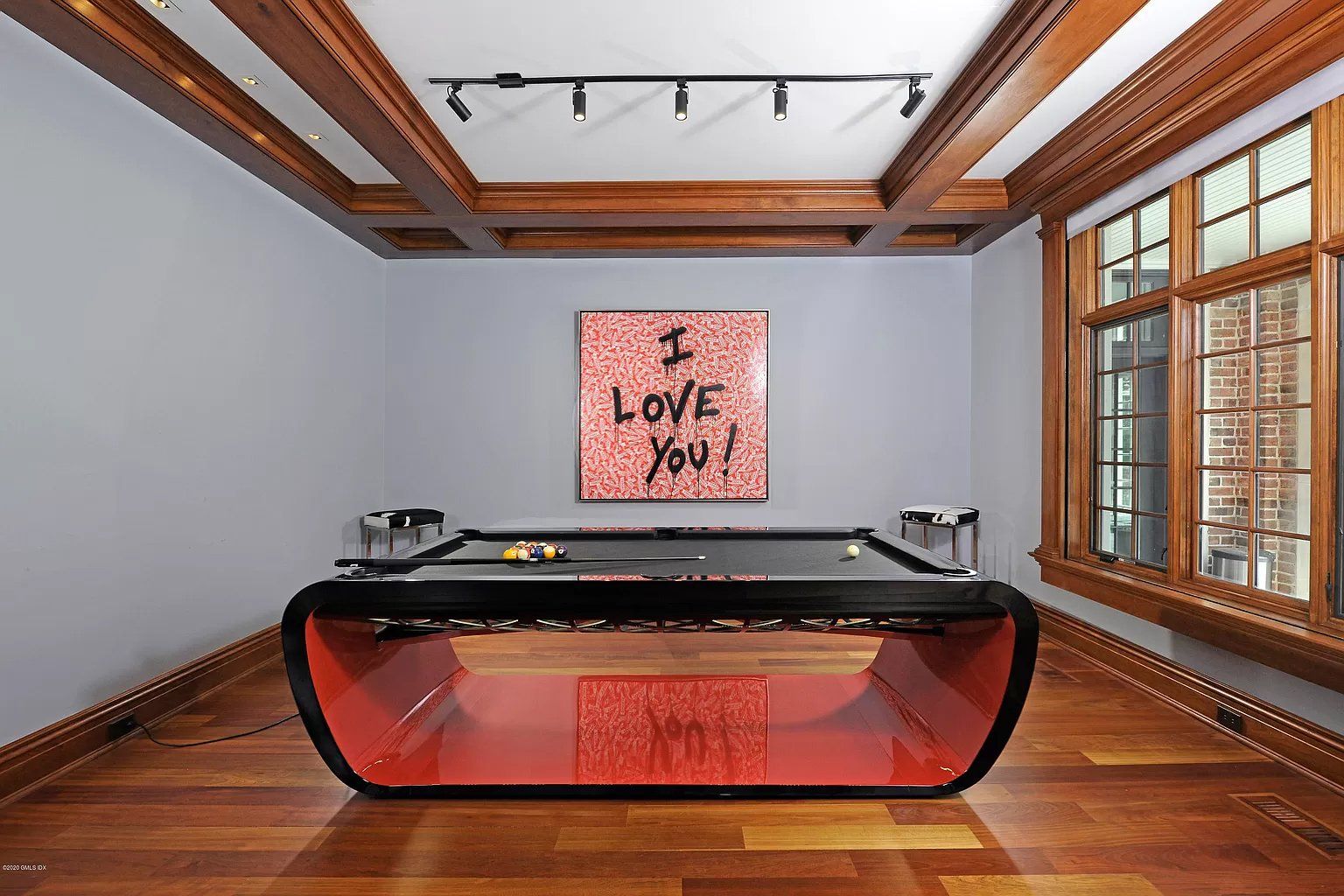 Game room with hardwood flooring and beams