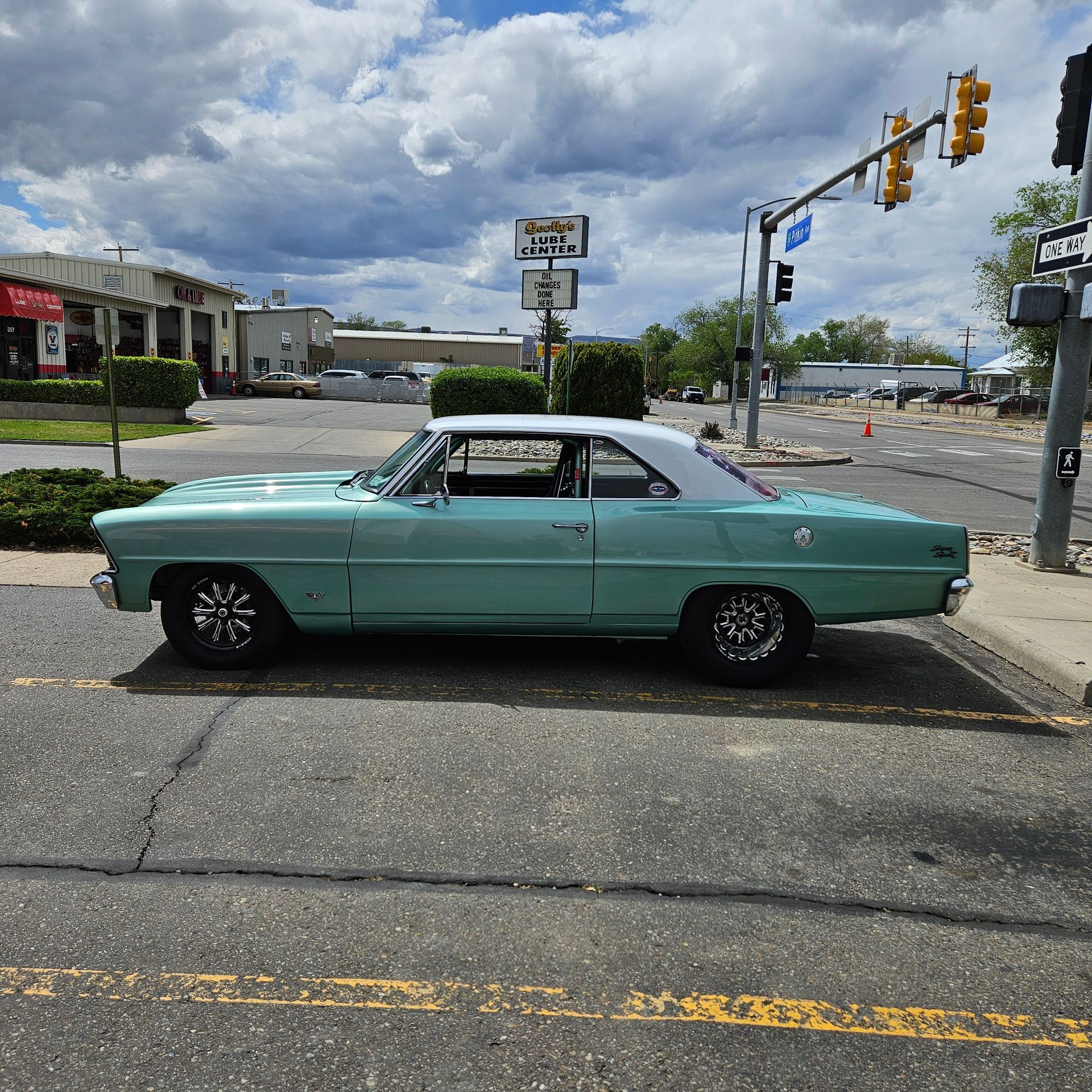 A green car is parked on the side of the road