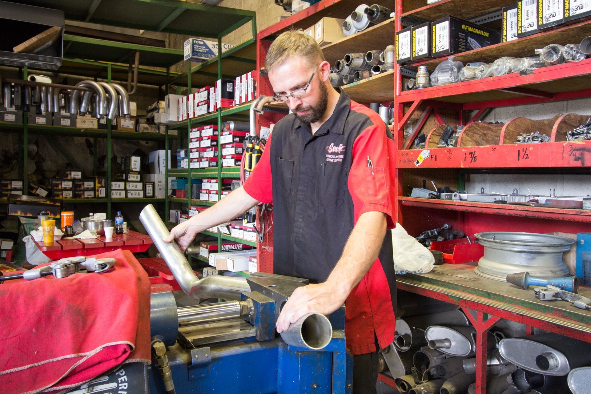 A man is working on a piece of metal in a shop.