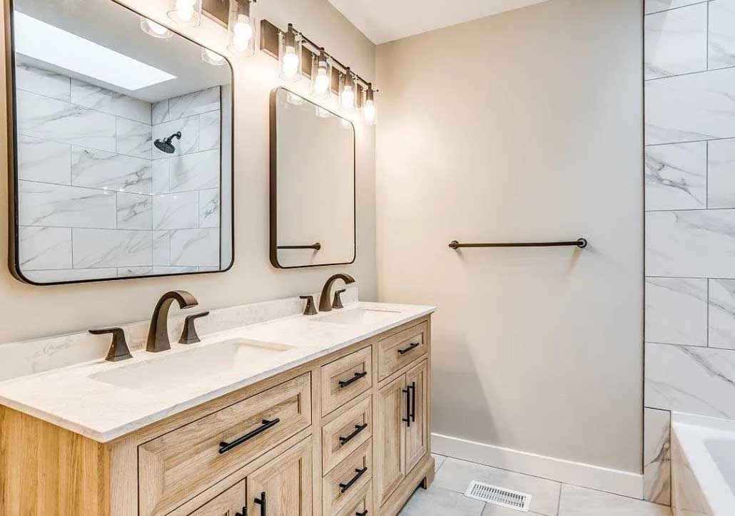 A bathroom with two sinks , a mirror , and a bathtub.