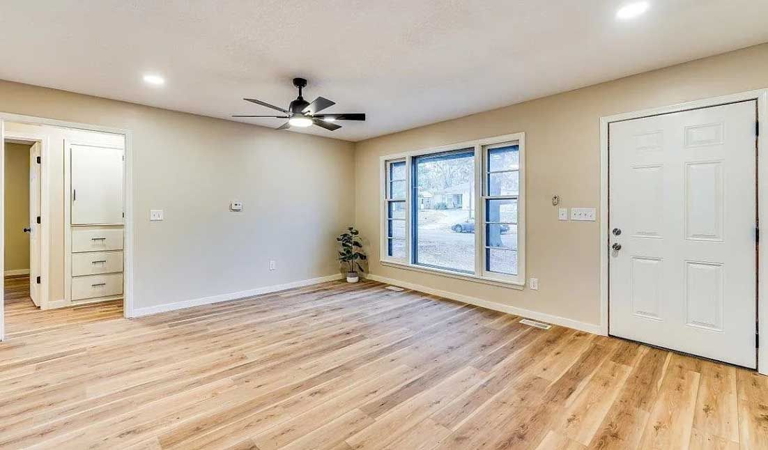 A living room with hardwood floors and a ceiling fan.