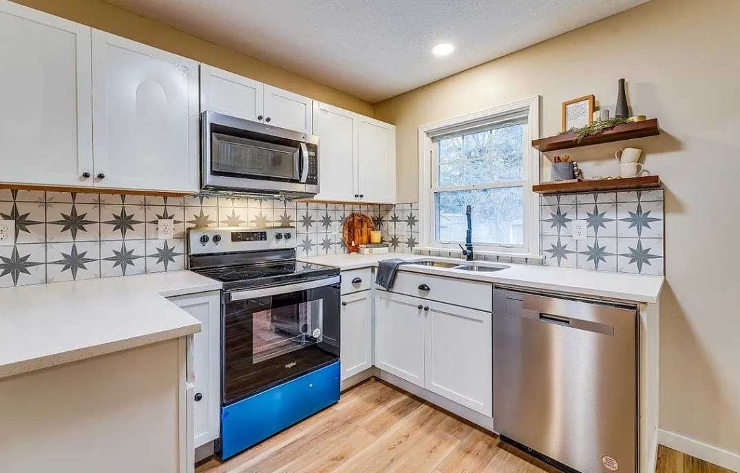 A kitchen with white cabinets and stainless steel appliances.