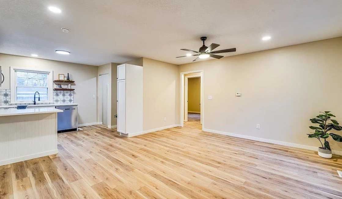 A living room with hardwood floors and a ceiling fan.