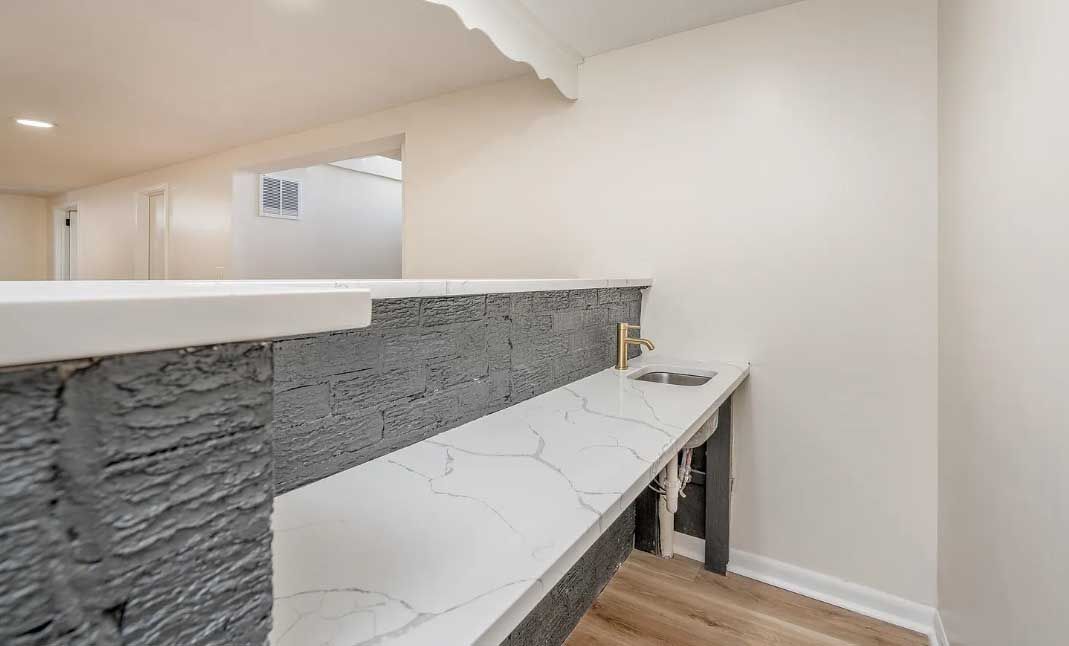 A kitchen with a long counter top and a sink.